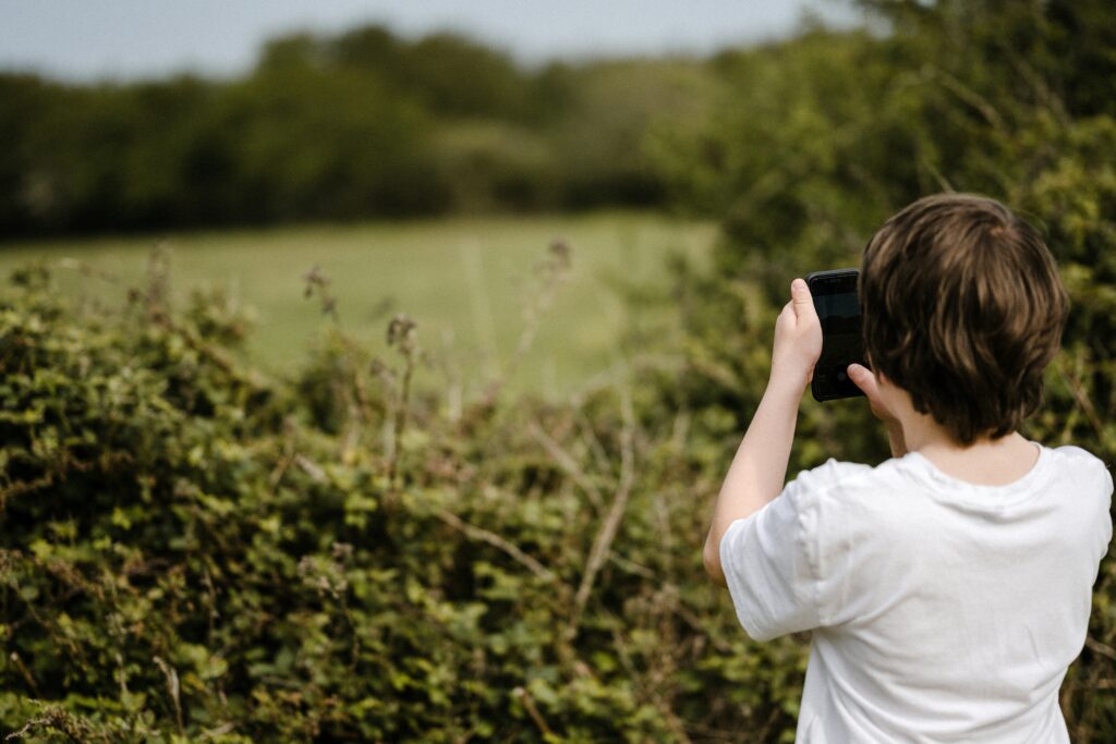 Tween taking photo of field